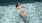 woman floats on her back in swimming pool